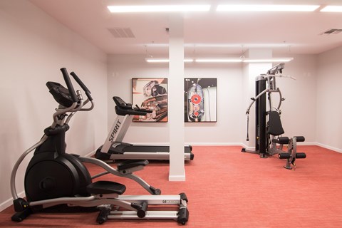 A gym with a red carpet and various exercise equipment.