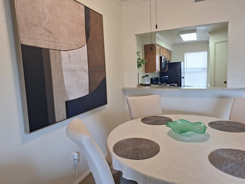 A modern dining room with a large abstract painting on the wall.