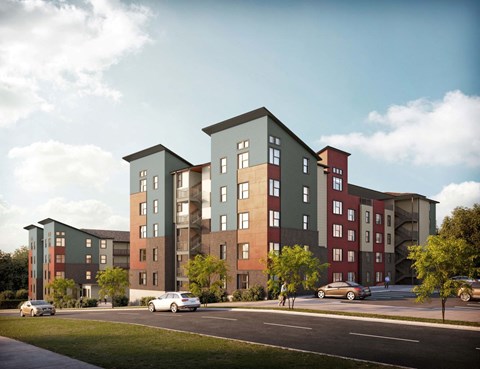 A modern apartment complex with cars parked in front.