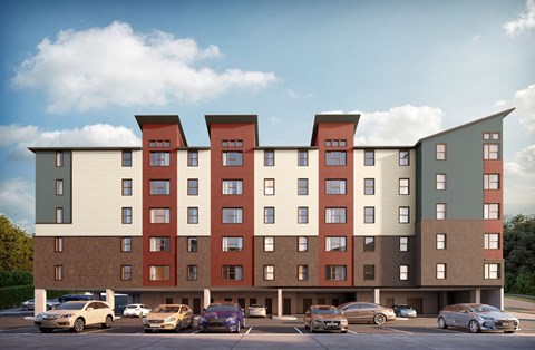 A large apartment building with a parking lot in front.