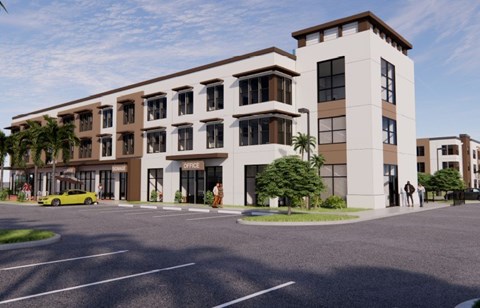 A modern building with a parking lot in front.