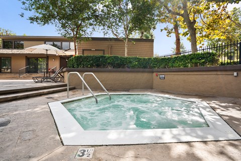 a hot tub in a backyard with a house in the background