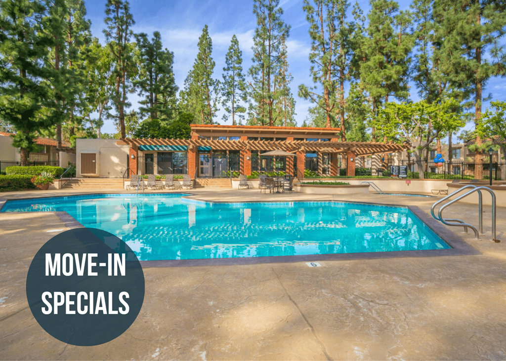 a large swimming pool with trees in the background and a sign that reads move in