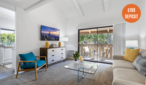 A living room with a blue chair and a glass coffee table.