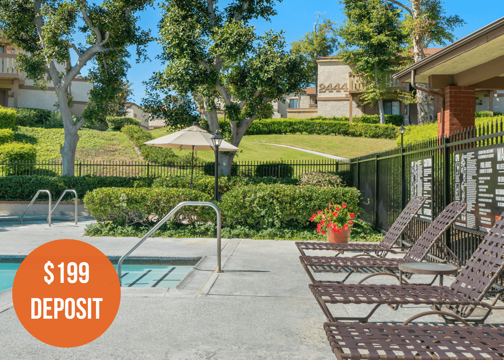 a swimming pool with two lounge chairs in front of a house