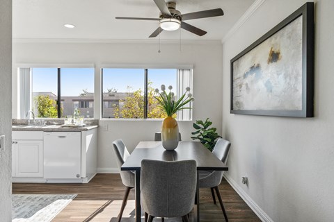 a dining room with a table and chairs and a ceiling fan
