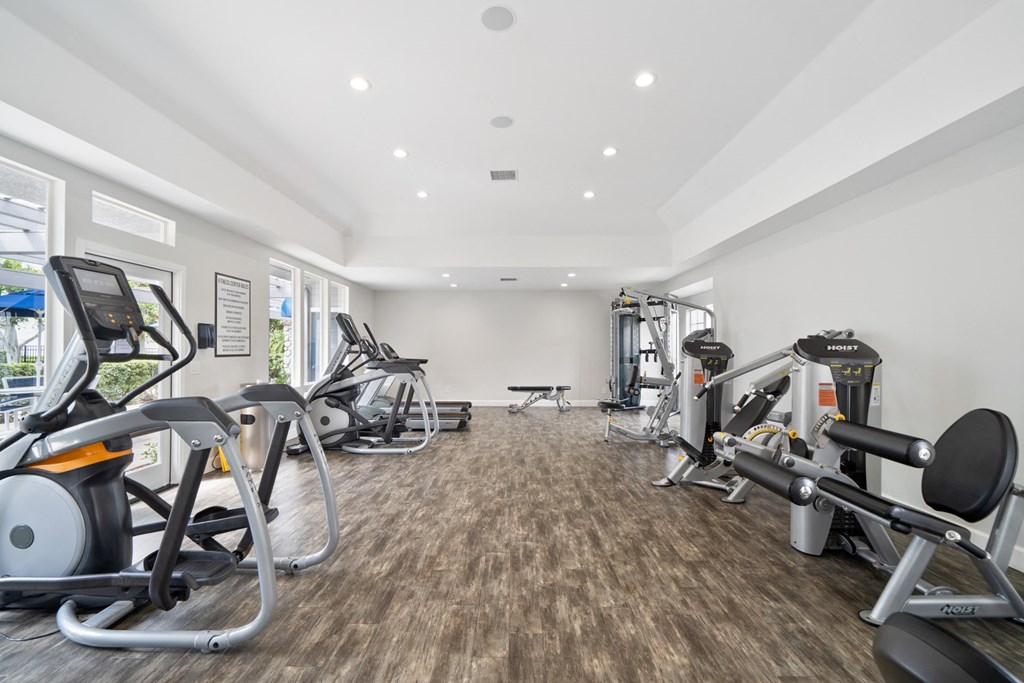 a gym with cardio machines and weights on the floor