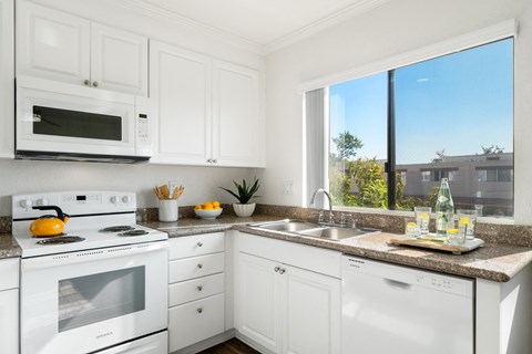 a kitchen with white appliances and a window