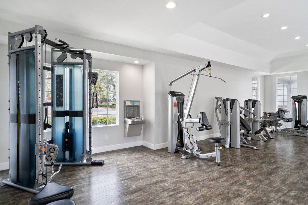 a gym with weights and cardio equipment in a home with a window