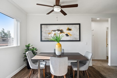 a dining room with a table and chairs and a ceiling fan