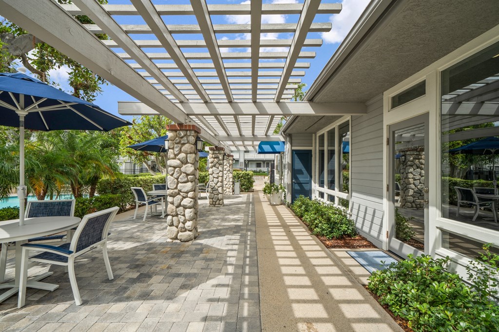 a covered patio with tables and chairs and umbrellas