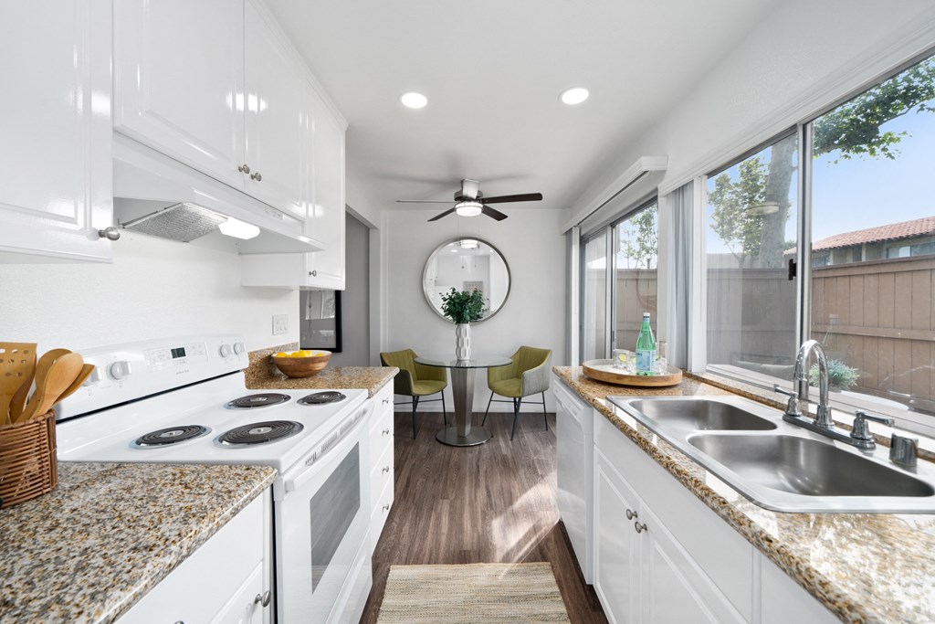a kitchen with white cabinets and granite counter tops