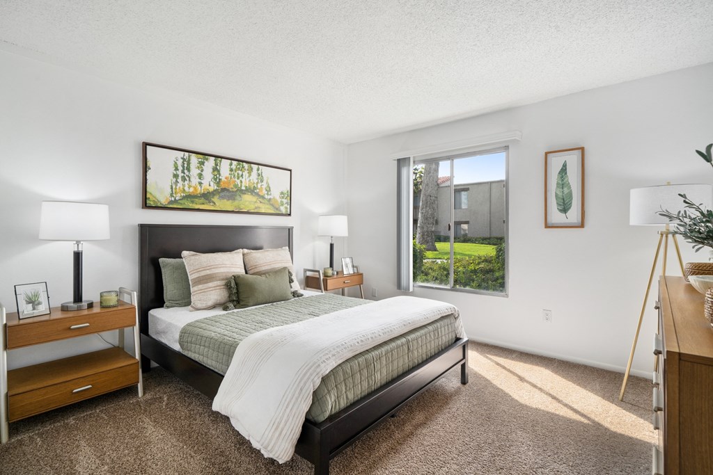 a bedroom with a bed and a large window