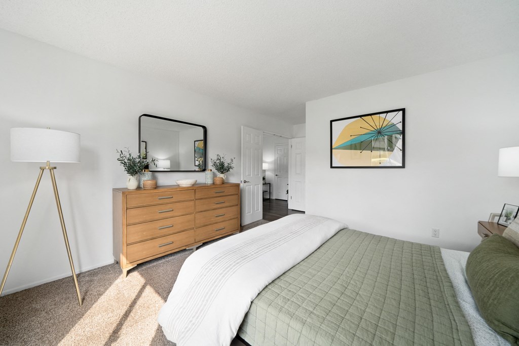 a bedroom with a bed and a dresser and a mirror