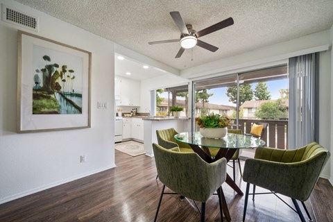 a dining area with a table and chairs and a ceiling fan
