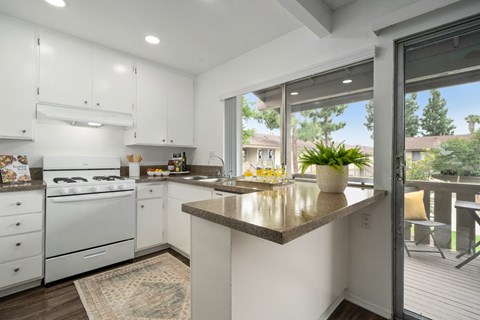a kitchen with white appliances and a counter top and a window