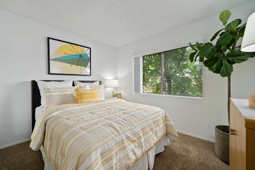 a bedroom with a bed and a large window