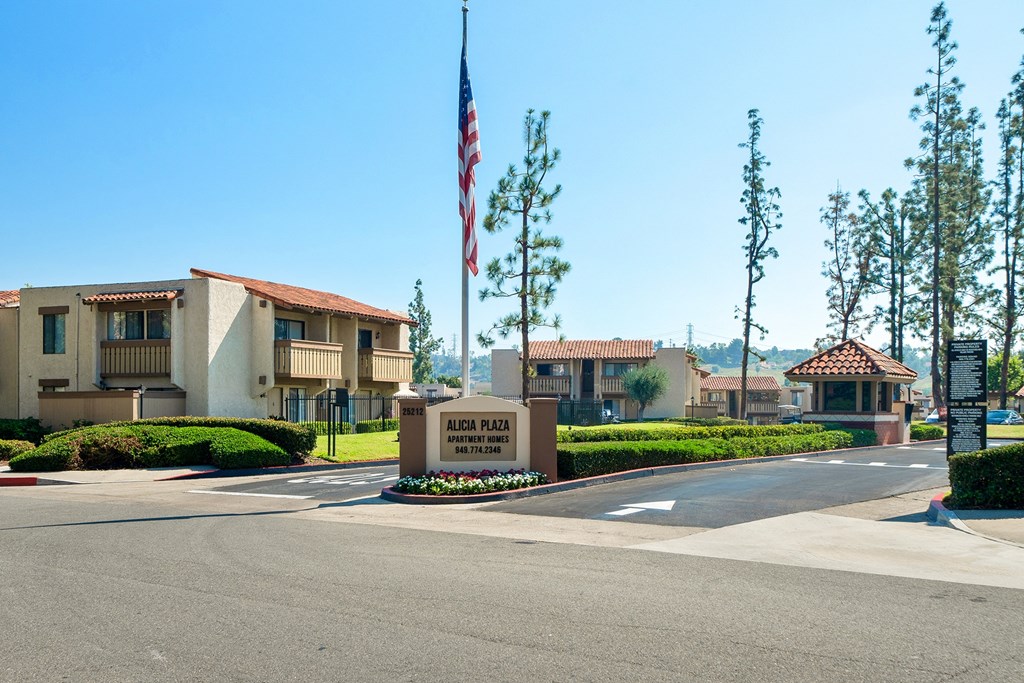 an empty street in front of an apartment building with an flag in front