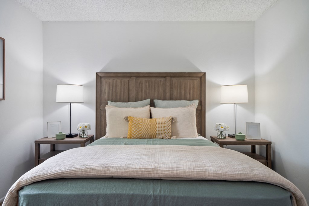 a bedroom with a bed and two night stands with lamps