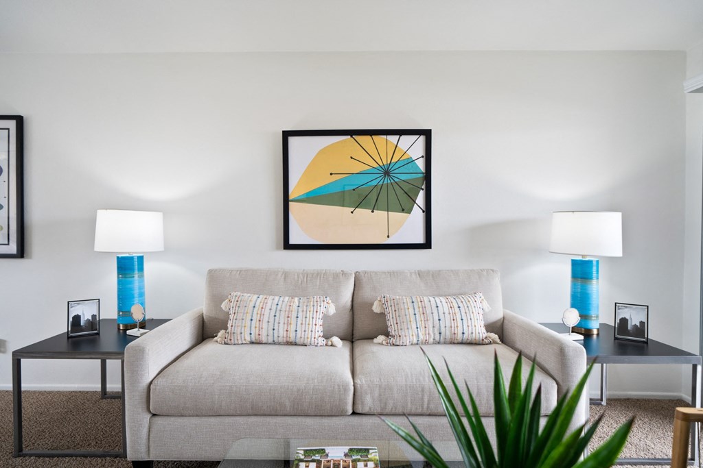 a living room with a beige couch and two blue lamps