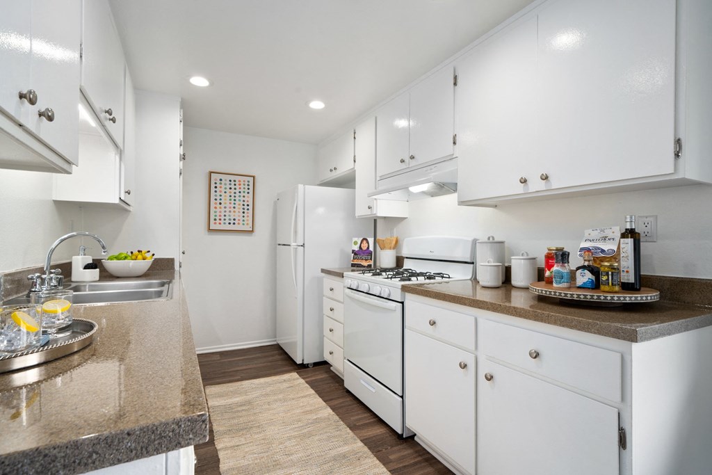 a kitchen with white cabinets and white appliances