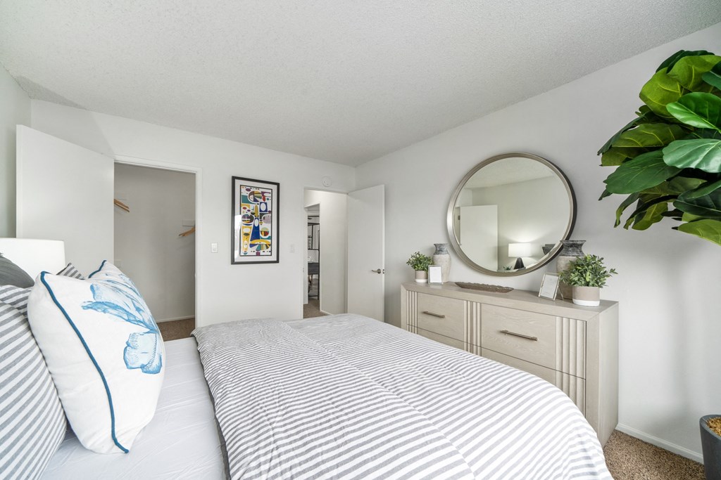 a bedroom with a large bed and a mirror