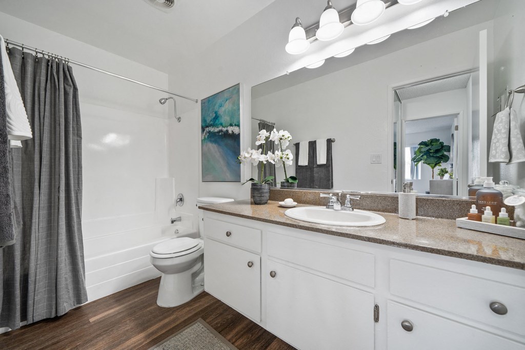 a bathroom with white cabinets and a large mirror