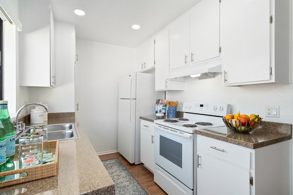 a white kitchen with white appliances and white cabinets