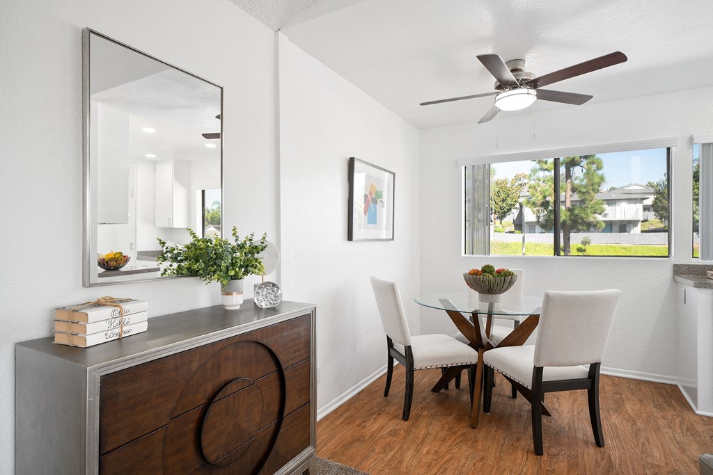 a dining room with a table and chairs and a ceiling fan