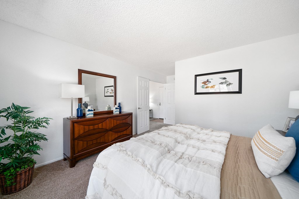 a bedroom with a bed and a dresser with a mirror