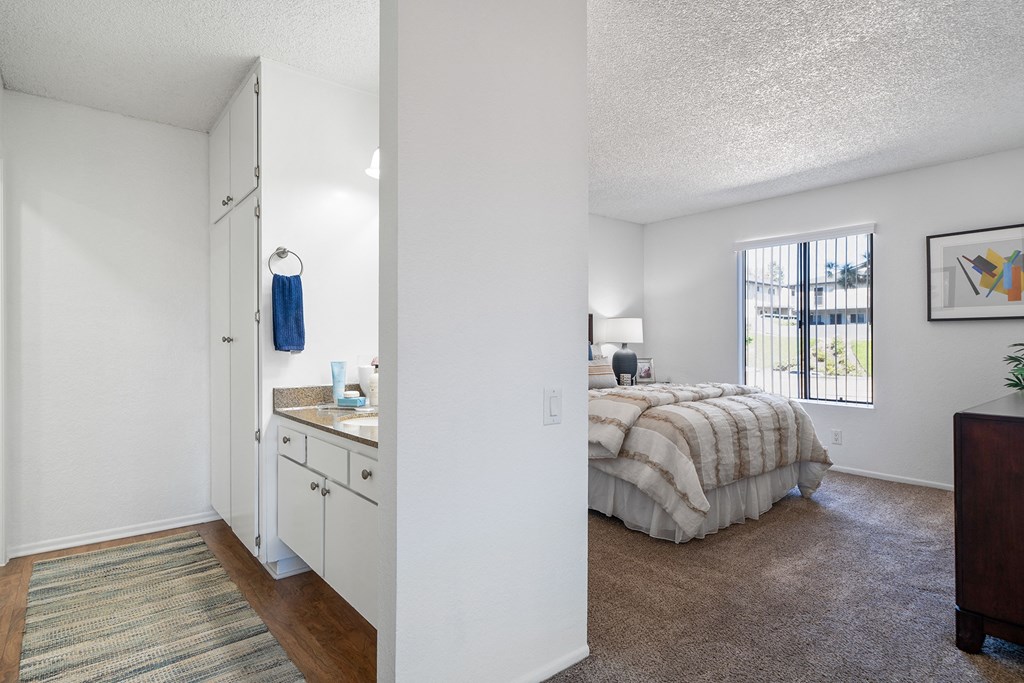 a bedroom with a bed and a sink and a window