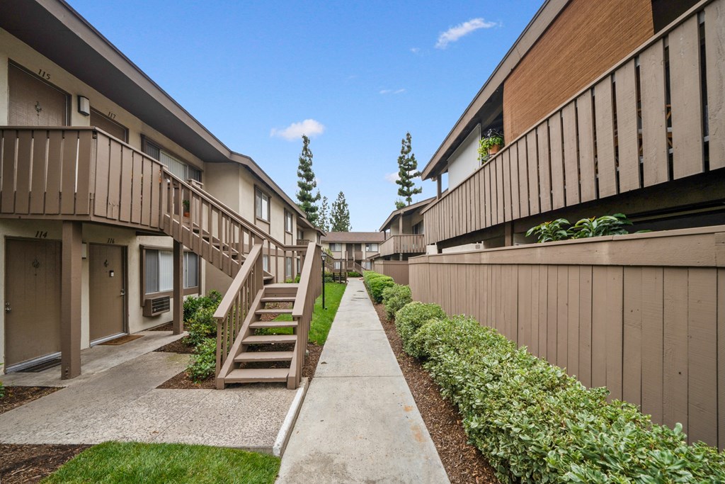 a view of the pathway between the buildings at the whispering winds apartments in pearland, tx