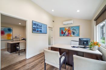 a home office with a desk and chairs and a computer