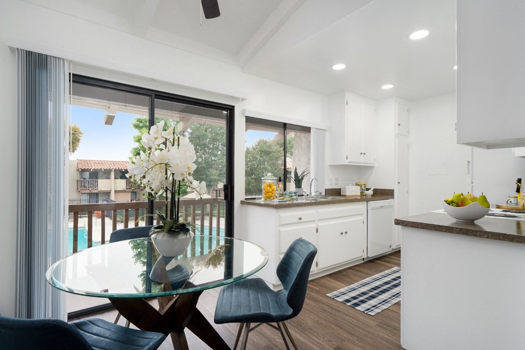 a kitchen and dining area with a glass table and chairs