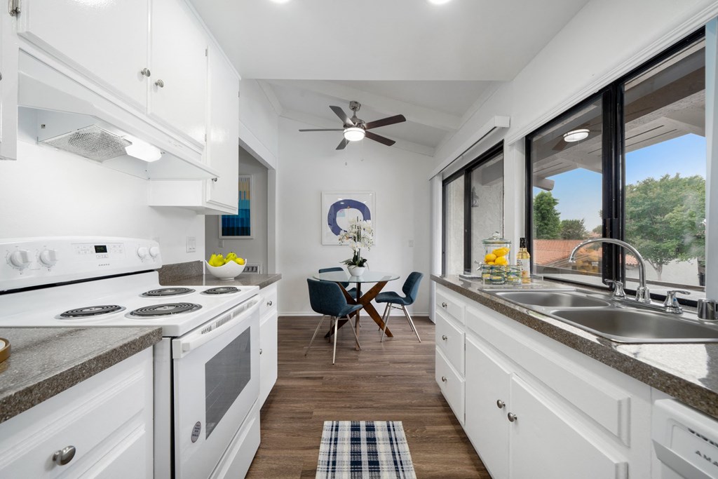 a kitchen with white cabinets and stainless steel appliances and a large window