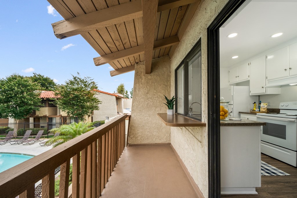 a long balcony with a kitchen and a pool