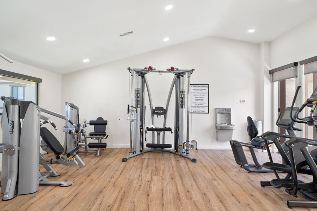 a fitness room with treadmills and other exercise equipment