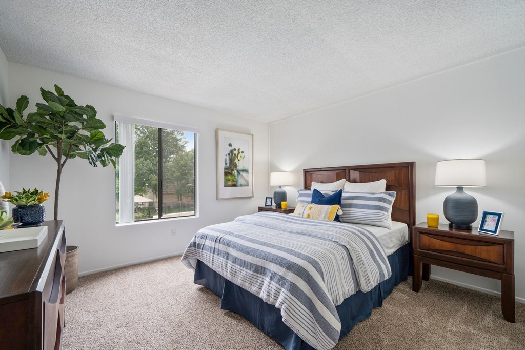 a bedroom with a bed and a dresser and a window
