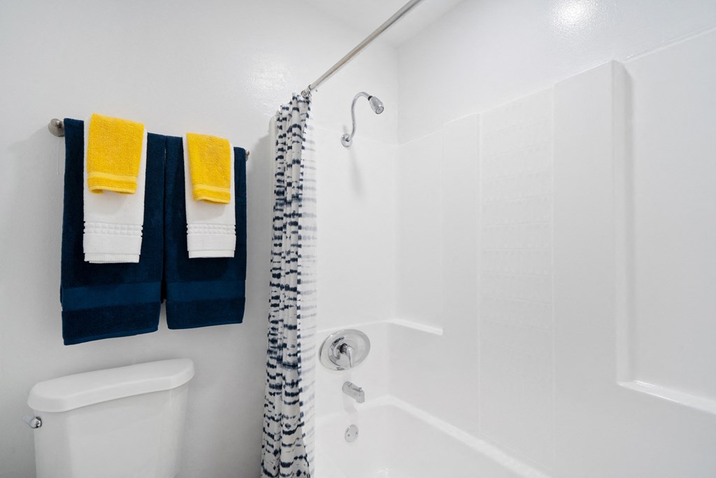 a bathroom with a shower and two towels on a rack
