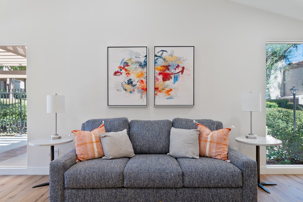 a living room with a couch and two paintings on the wall