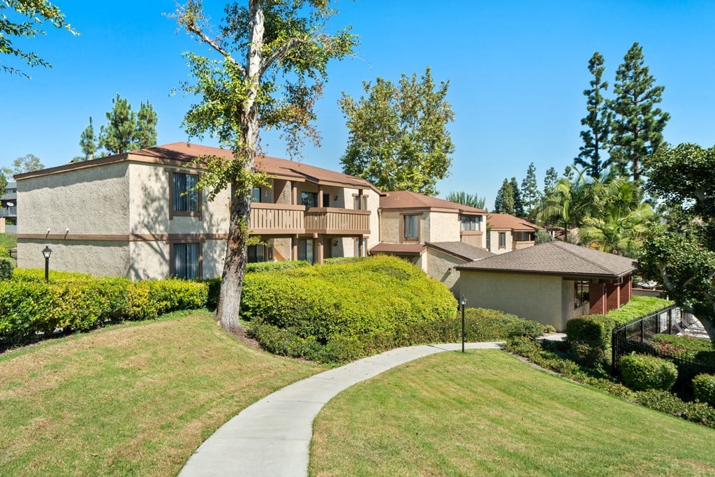 a sidewalk in front of a row of houses