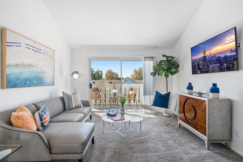 a living room with a couch and a coffee table and a large window