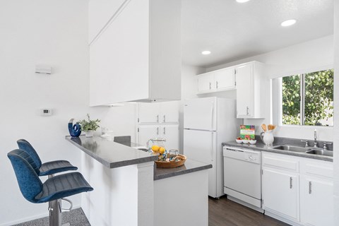 a kitchen with white cabinets and a counter top and a sink