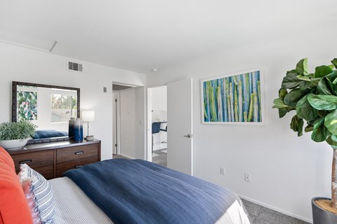 a bedroom with a bed and a dresser and a mirror