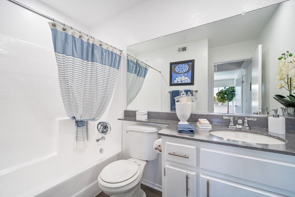 a white bathroom with a white toilet and a tub and a sink
