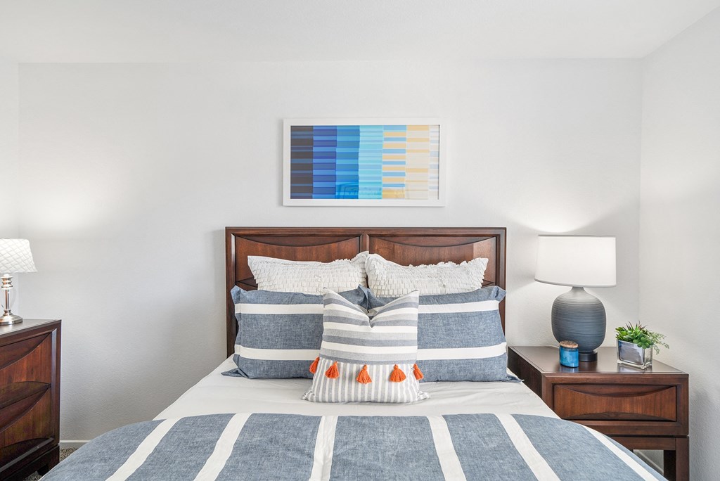 a bedroom with a bed with blue and white pillows