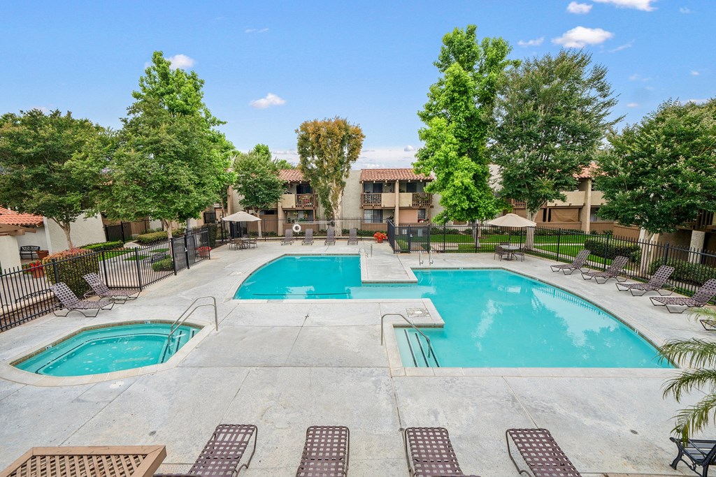 our apartments have a swimming pool with chairs and trees