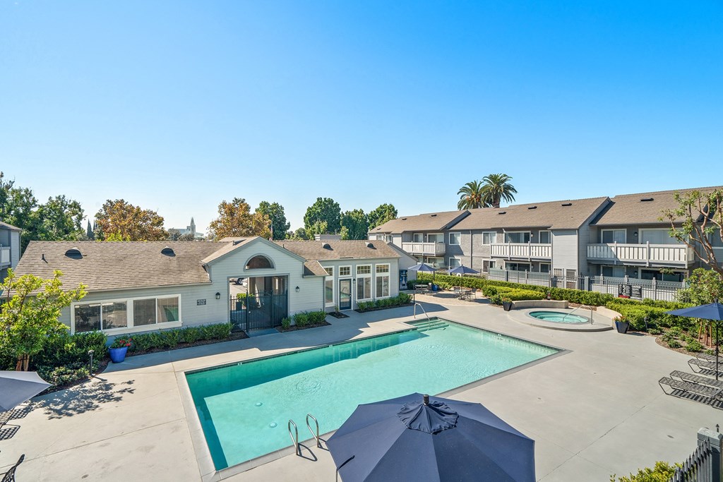 the view of a swimming pool with apartments in the background