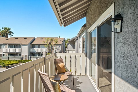 a terrace with chairs and a table and a view of a building and a