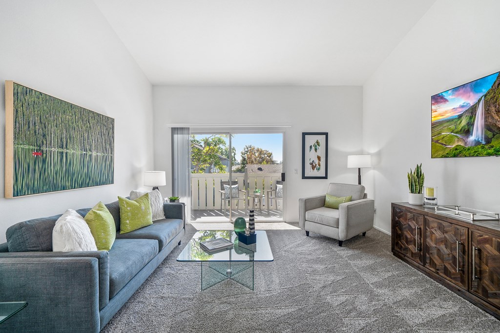 a living room with a blue couch and a glass coffee table